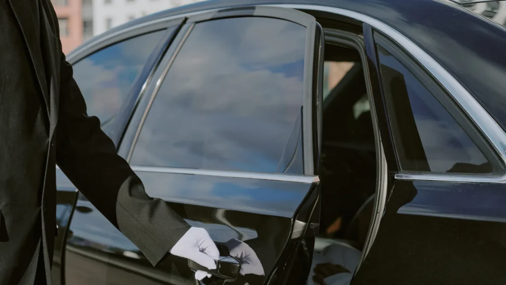 Male Chauffeur Opening Car Door for Businessperson Entering Vehicle